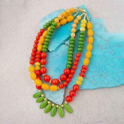 Colorful beaded necklace on a textured blue and gray background