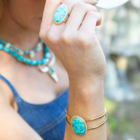 Close-up of a person wearing turquoise jewelry with a blurred background