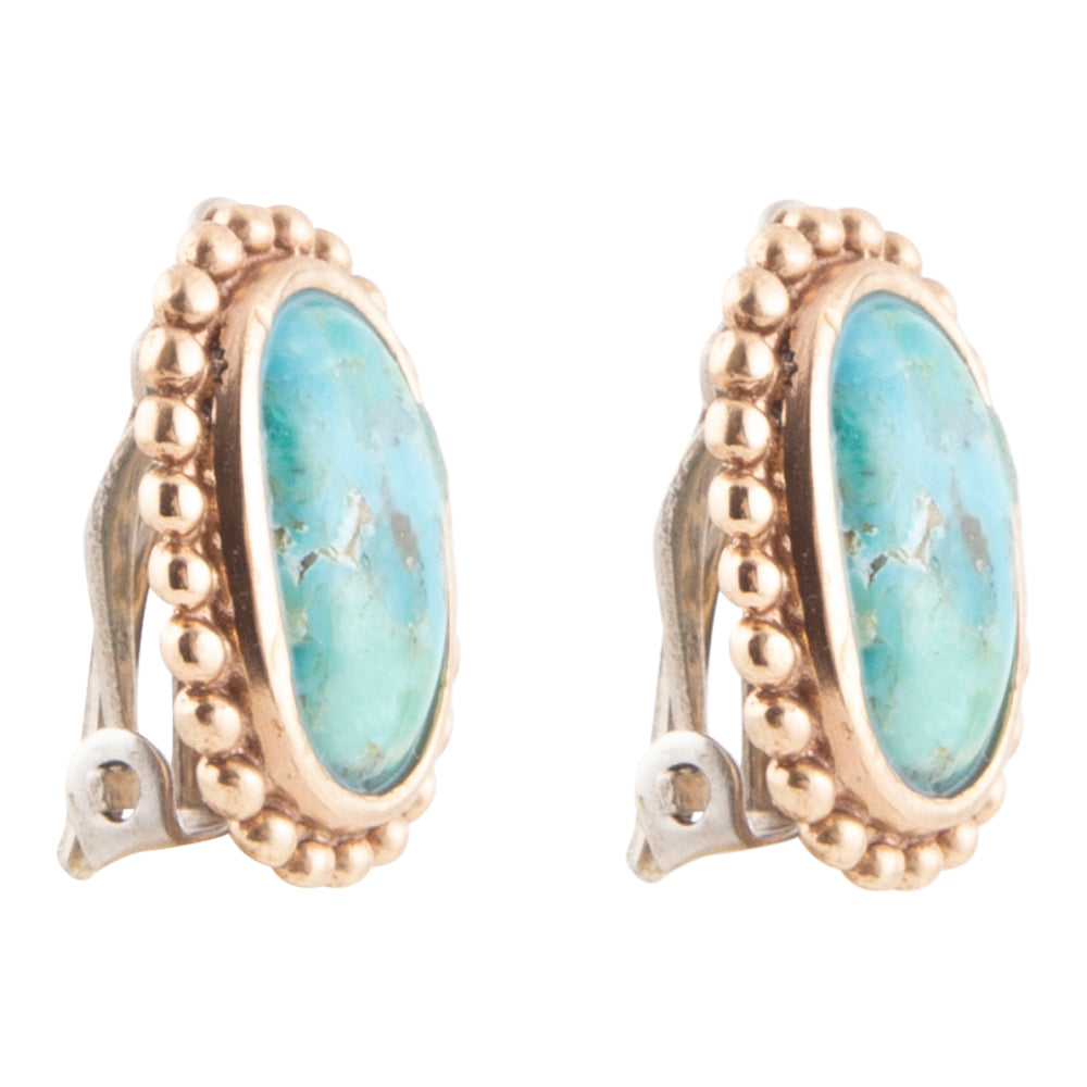 Gold earrings with turquoise stones on a white background
