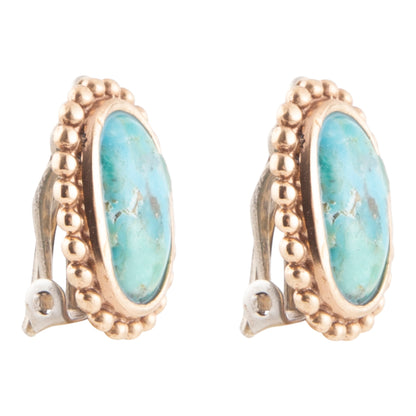 Gold earrings with turquoise stones on a white background