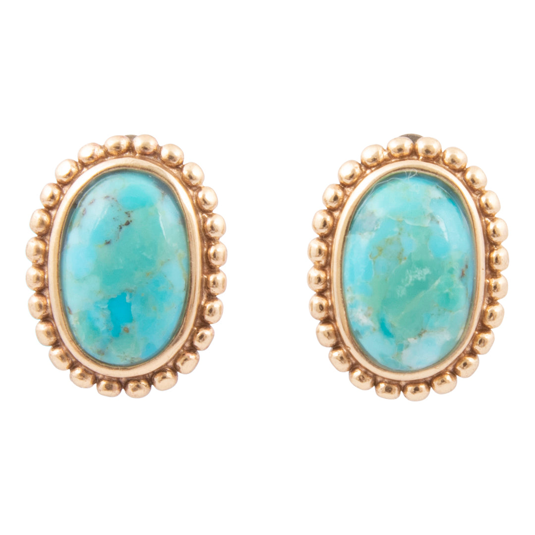 Pair of gold earrings with turquoise stones on a white background