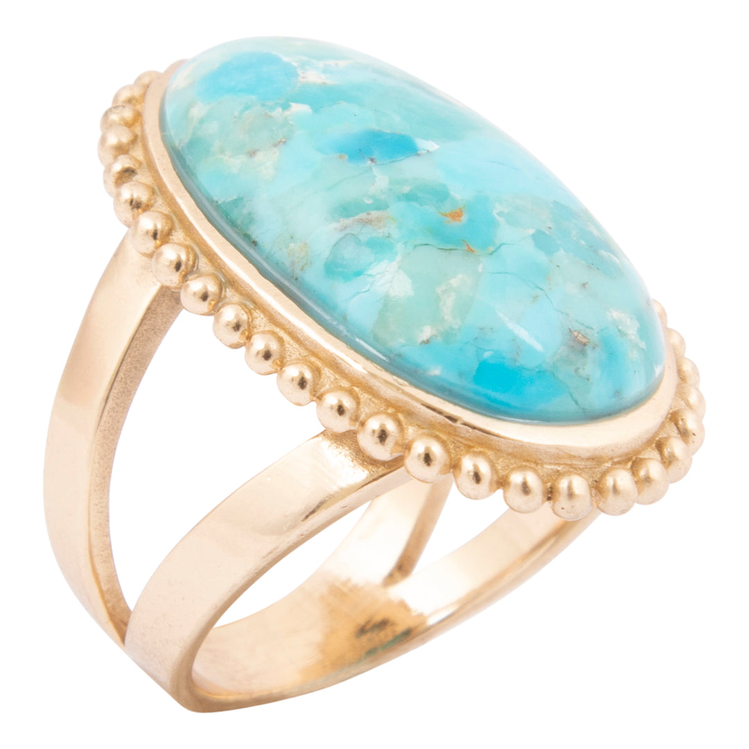 Gold ring with a large turquoise stone on a white background
