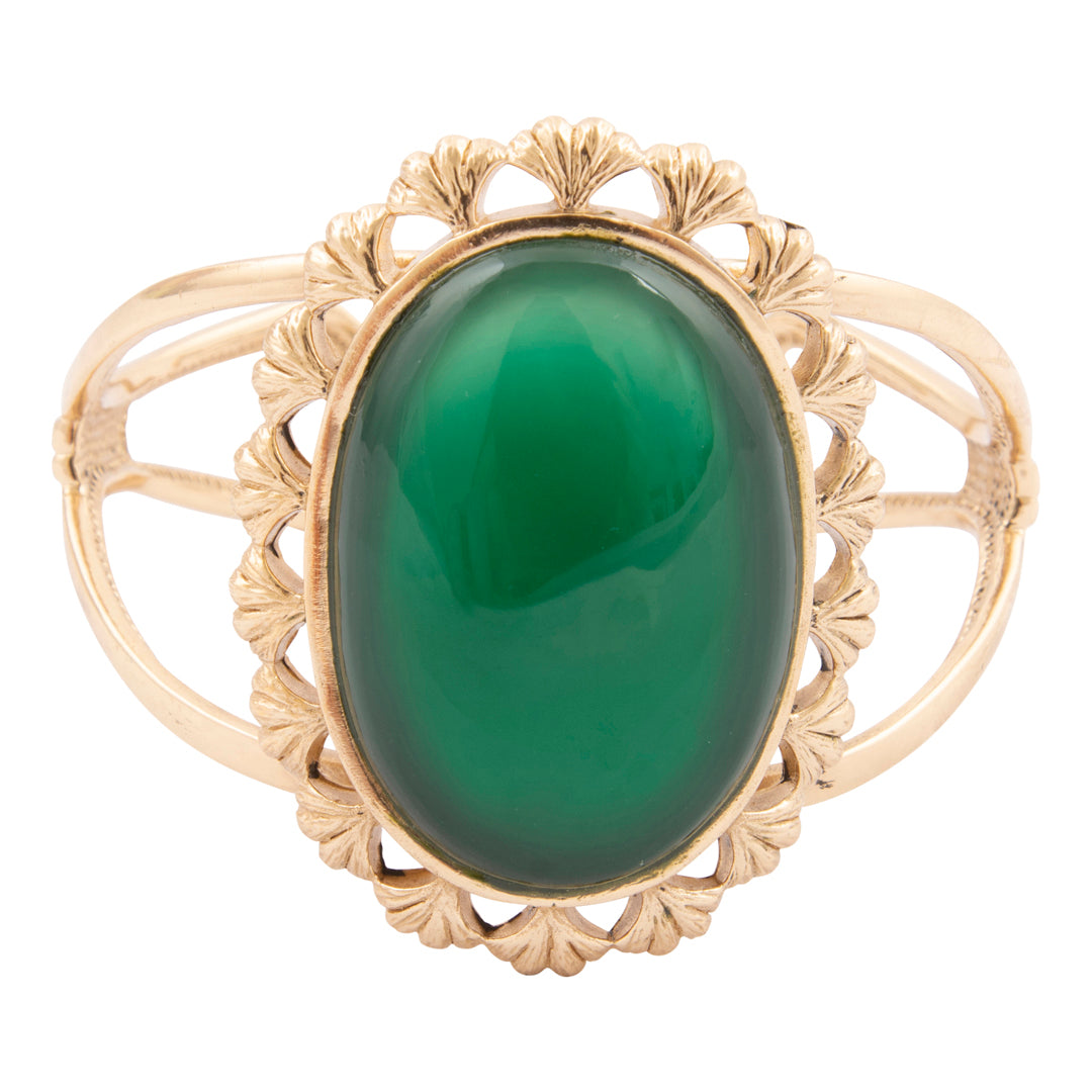 Gold ring with a green gemstone on a white background