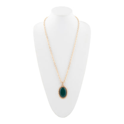 Gold necklace with a green pendant on a white stand