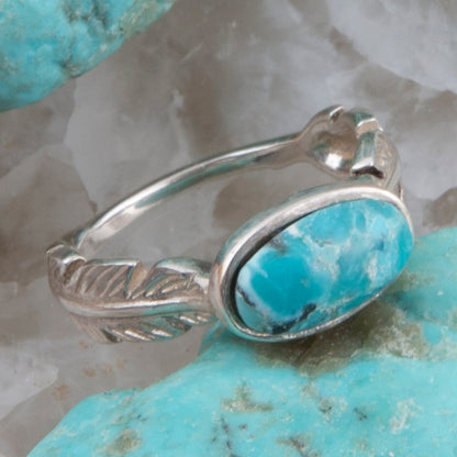 Silver ring with turquoise stone on a textured turquoise stone background