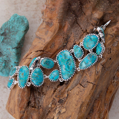 Turquoise bracelet with silver accents on a wooden surface