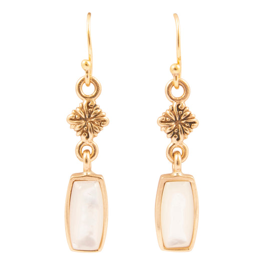 Gold earrings with floral designs and white stones on a white background