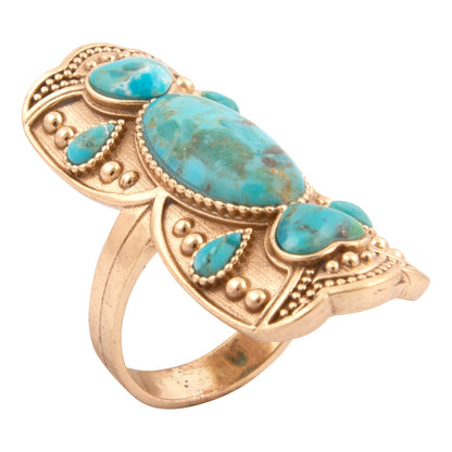 Gold ring with turquoise stones on a white background