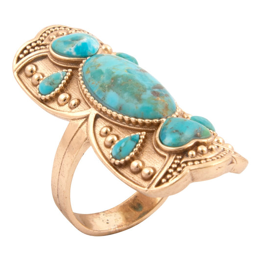 Gold ring with turquoise stones on a white background