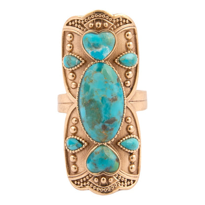 Gold ring with turquoise stones on a white background