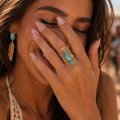 Woman with turquoise ring and earrings on a beach