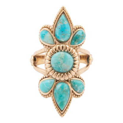 Gold ring with turquoise stones on a white background