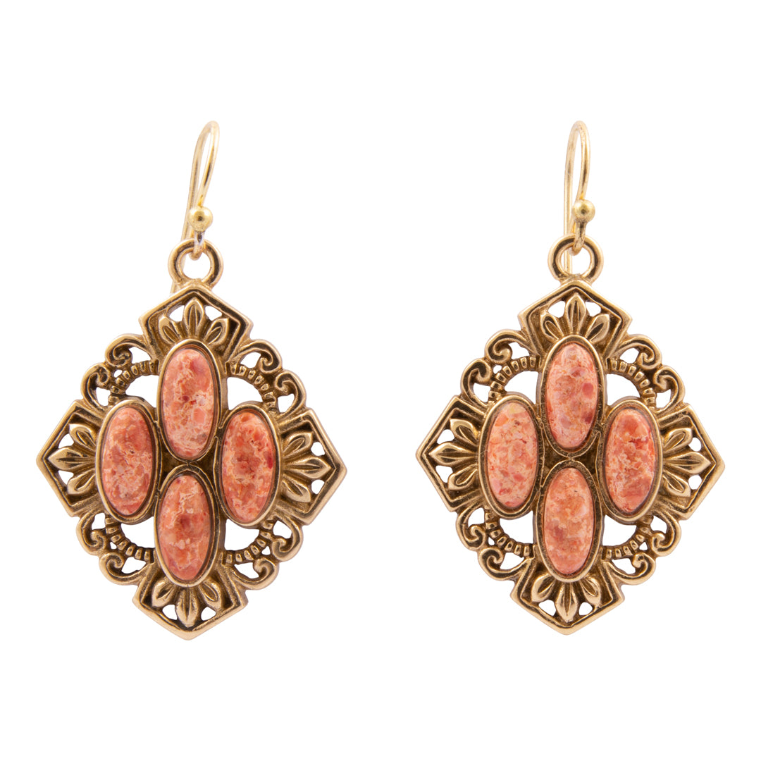 Pair of ornate earrings with pink stones on a white background