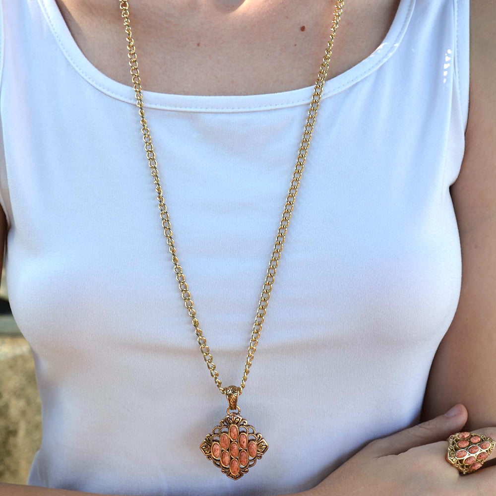Gold necklace with a decorative pendant on a white shirt