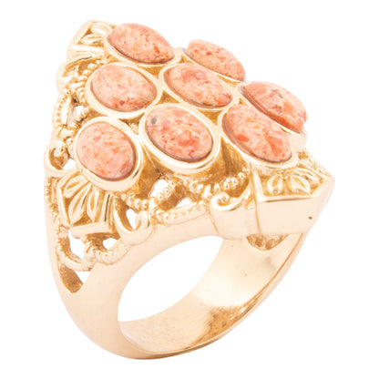Gold ring with pink stones on a white background