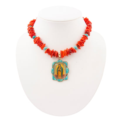 Necklace with red beads and a central pendant on a white stand