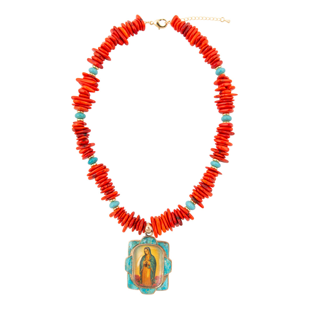 Necklace with red coral beads and a religious pendant on a white background