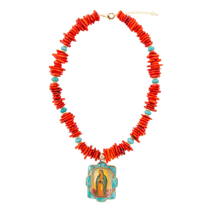Necklace with red coral beads and a religious pendant on a white background