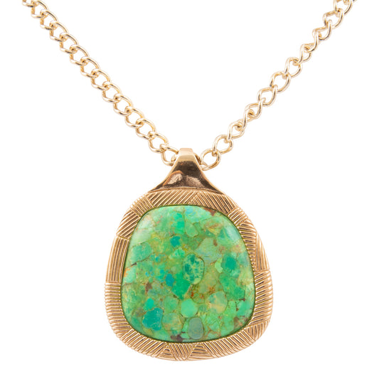 Gold necklace with a green stone pendant on a white background