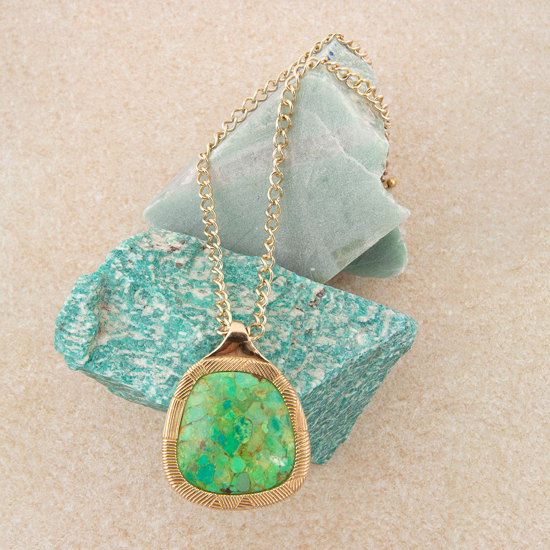 Necklace with a green stone pendant on a textured surface