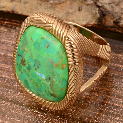 Gold ring with a large green stone on a wooden surface
