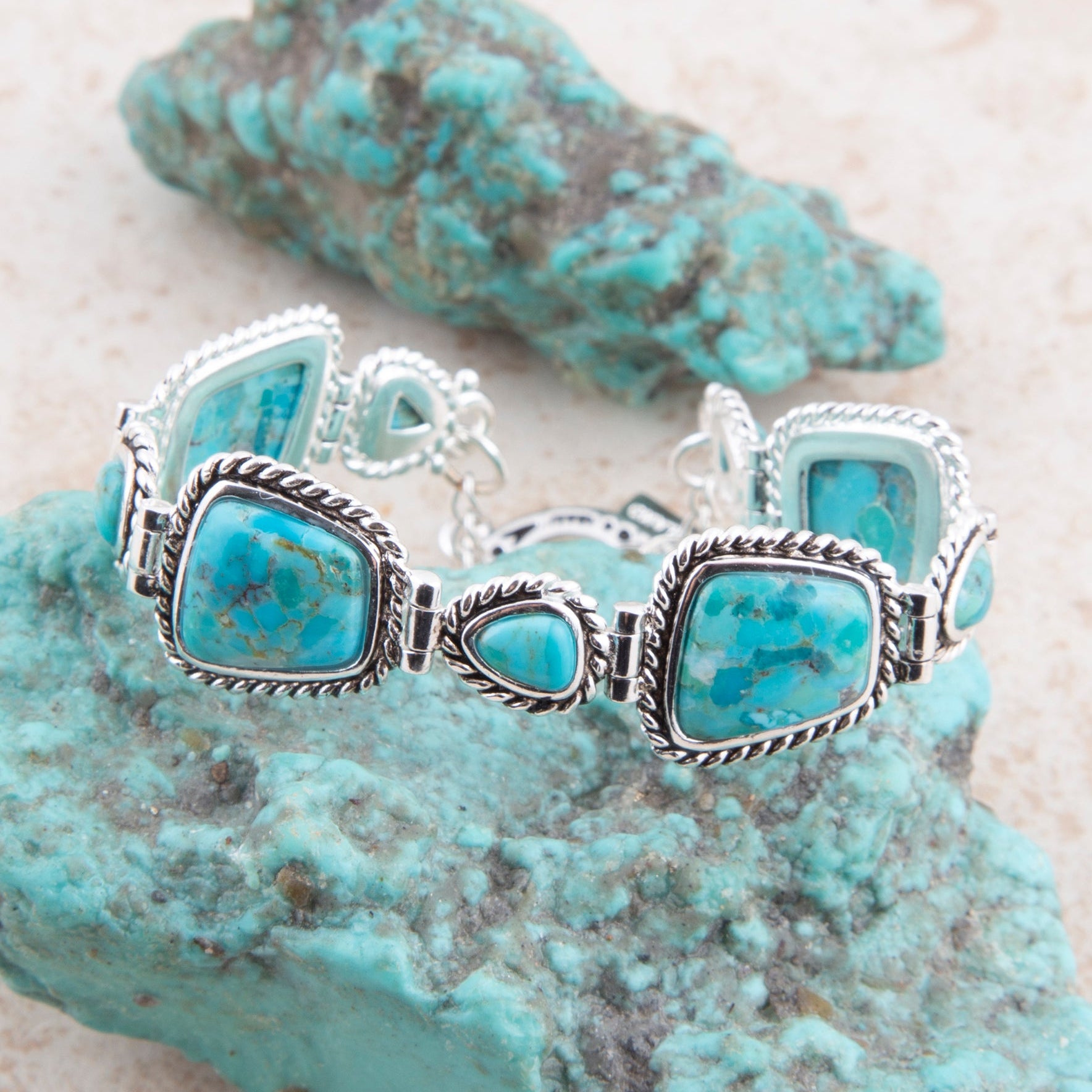 Turquoise bracelet with silver accents on a turquoise stone background