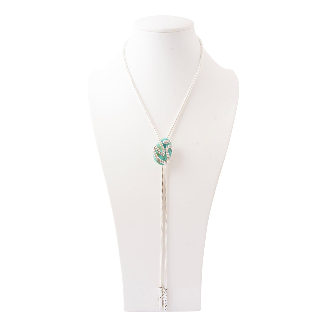 A white cord bolo tie necklace with a knotted turquoise and white centerpiece, displayed on a white mannequin bust against a white background.