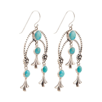 Pair of silver earrings with turquoise stones on a white background