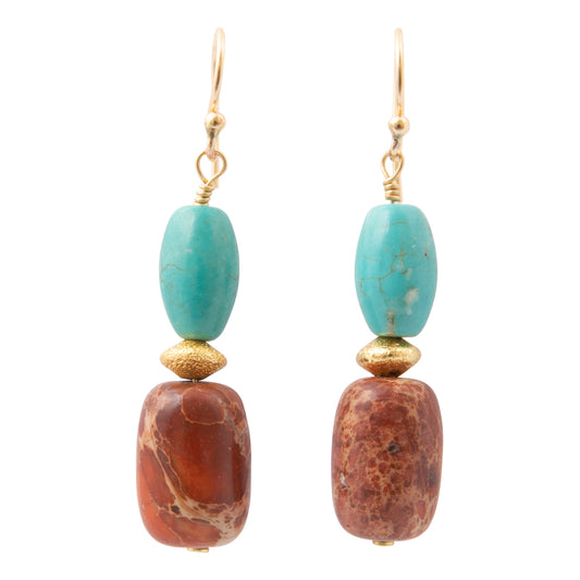 A pair of drop earrings featuring a turquoise-colored stone bead and a reddish-brown stone bead, separated by textured gold spacers, hanging from gold hooks on a white background.