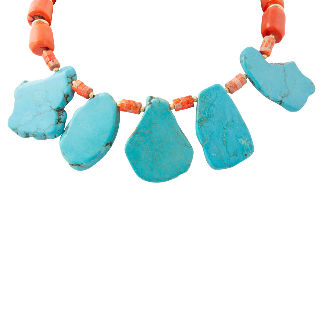 A turquoise and coral bead necklace featuring five large, irregular-shaped turquoise stones in the center, separated by small coral beads, on a plain white background.