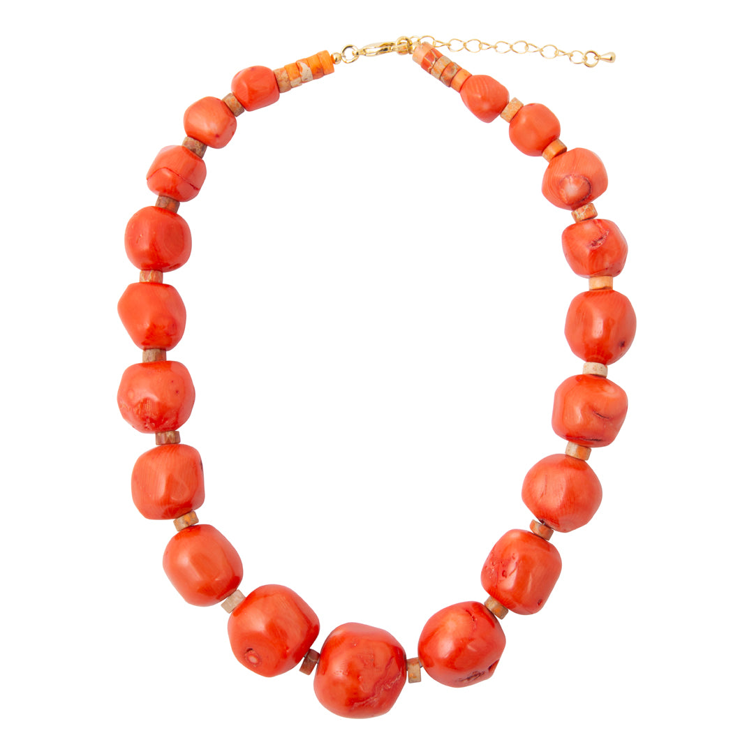 A coral-red beaded necklace with chunky, rounded beads separated by small gold spacer rings, completed with a gold-tone clasp and extender chain, shown on a plain white background.
