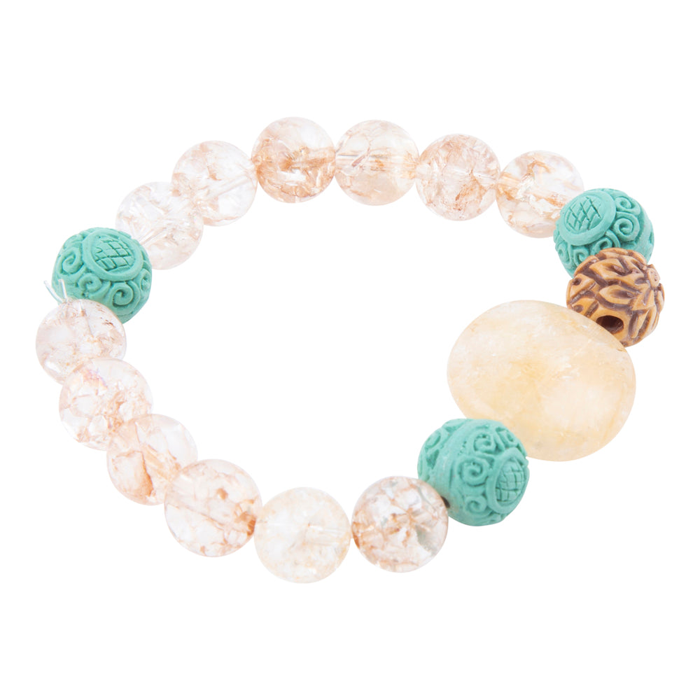 A beaded stretch bracelet featuring clear round beads with natural gold veining, a large smooth pale yellow stone, two turquoise carved beads, and one brown patterned bead, shown on a plain white background.