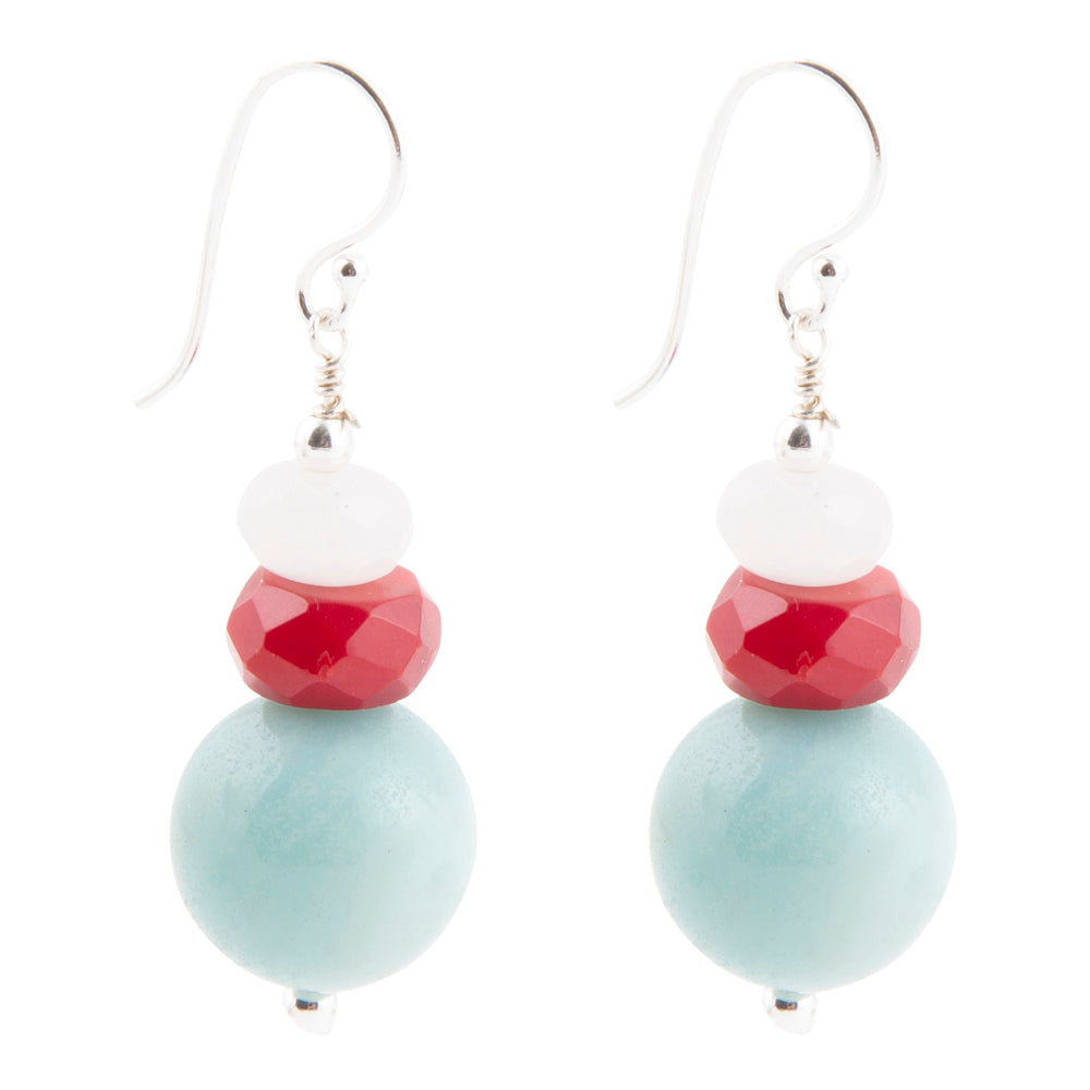 A pair of dangle earrings with silver fishhook wires, featuring a stacked bead design of white, faceted red, and large matte light blue beads on a white background.
