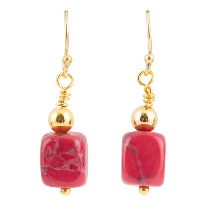 A pair of gold drop earrings featuring square pinkish-red stone beads with natural white and dark veining, suspended from gold fishhook wires and polished gold beads.