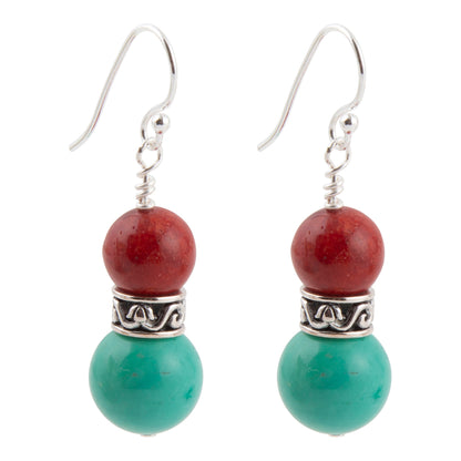 A pair of silver-toned dangle earrings featuring a round red bead, an ornate silver spacer, and a larger round turquoise green bead at the bottom, shown against a plain white background.
