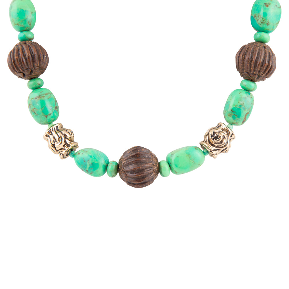 A beaded necklace featuring textured green turquoise-like beads, dark brown ribbed beads, and two antique gold rose-shaped spacers on a plain white background.