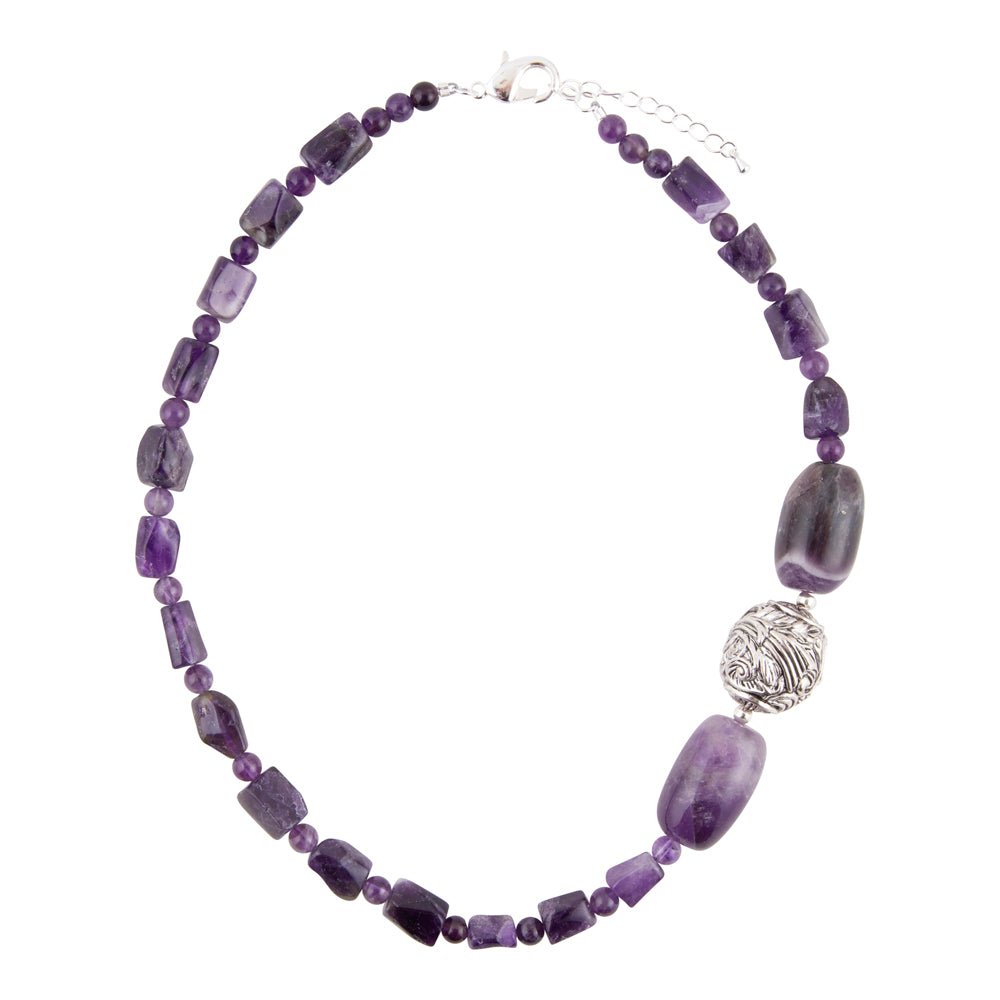 A beaded necklace featuring various shades of purple amethyst beads, a textured silver filigree accent bead, and a silver lobster clasp on a white background.