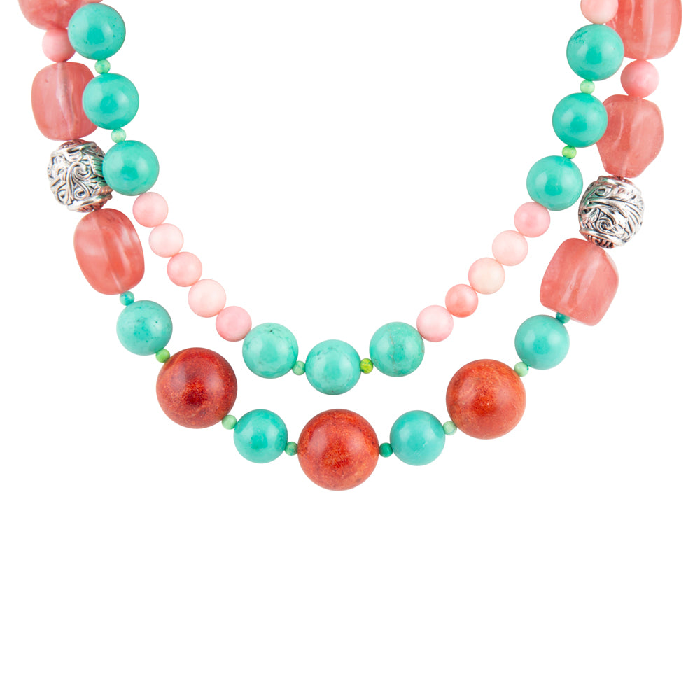 A multi-strand beaded necklace featuring coral red, turquoise, and light pink beads, accented by two silver filigree spacers, shown against a plain white background.