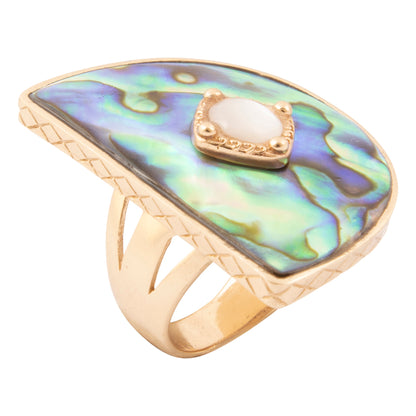 A gold ring featuring a large, irregular-shaped abalone shell inlay with iridescent green, blue, and purple hues, accented by a central oval white stone in a gold bezel.