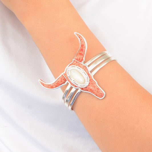 Silver bracelet with longhorn design on a wrist against a white background