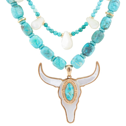 Turquoise beaded necklace with a longhorn bull head pendant on a white background