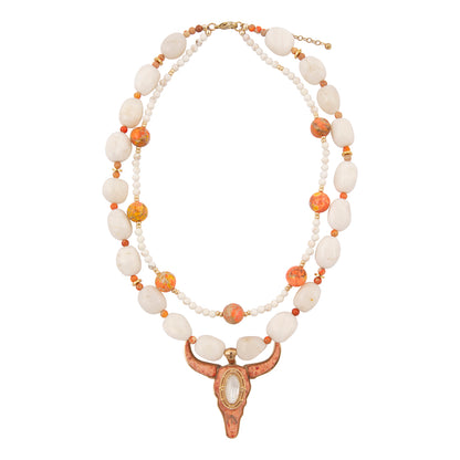 Necklace with white and orange beads and a decorative clasp on a white background