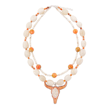Necklace with white and orange beads and a decorative clasp on a white background