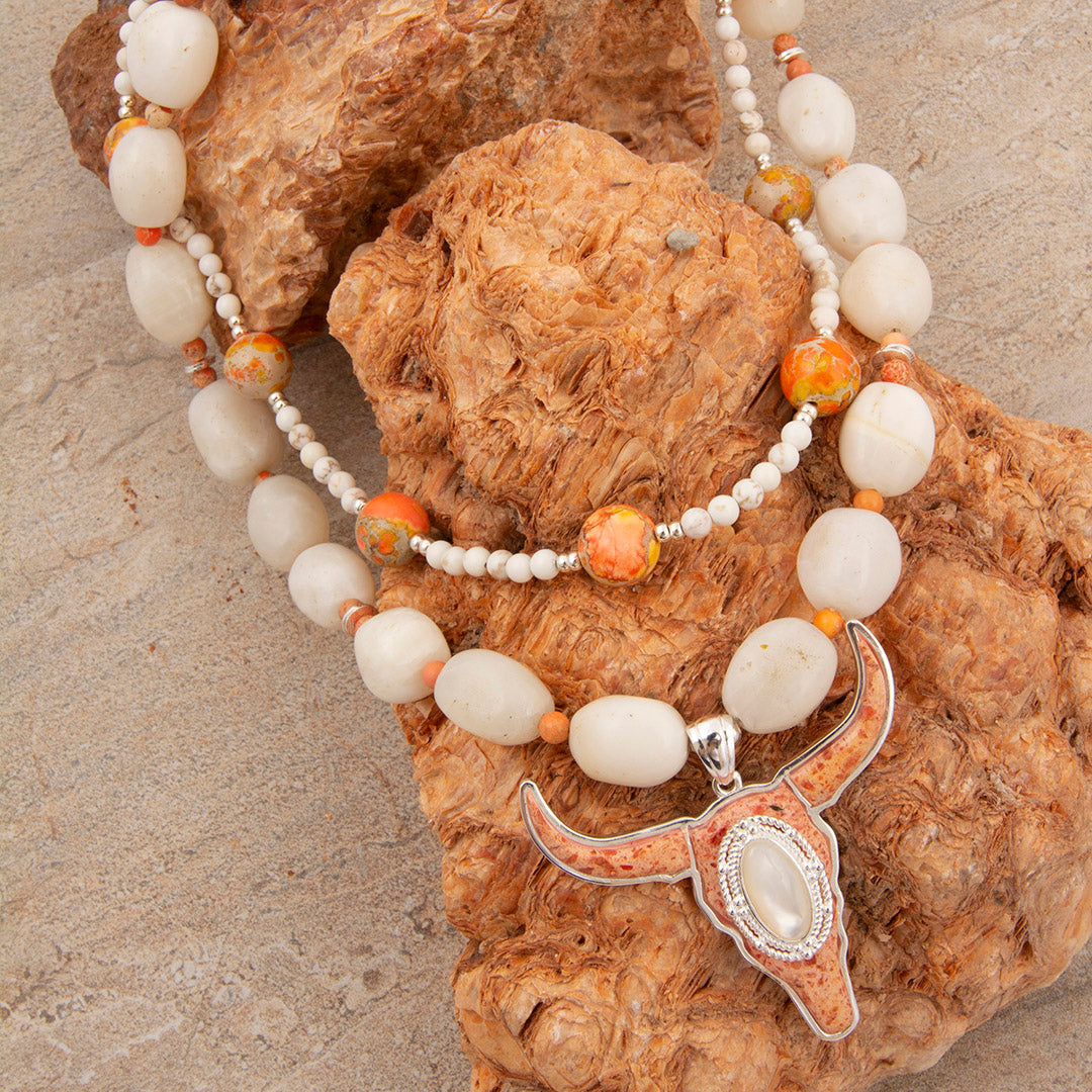 Necklace with longhorn bull pendant on a textured stone surface