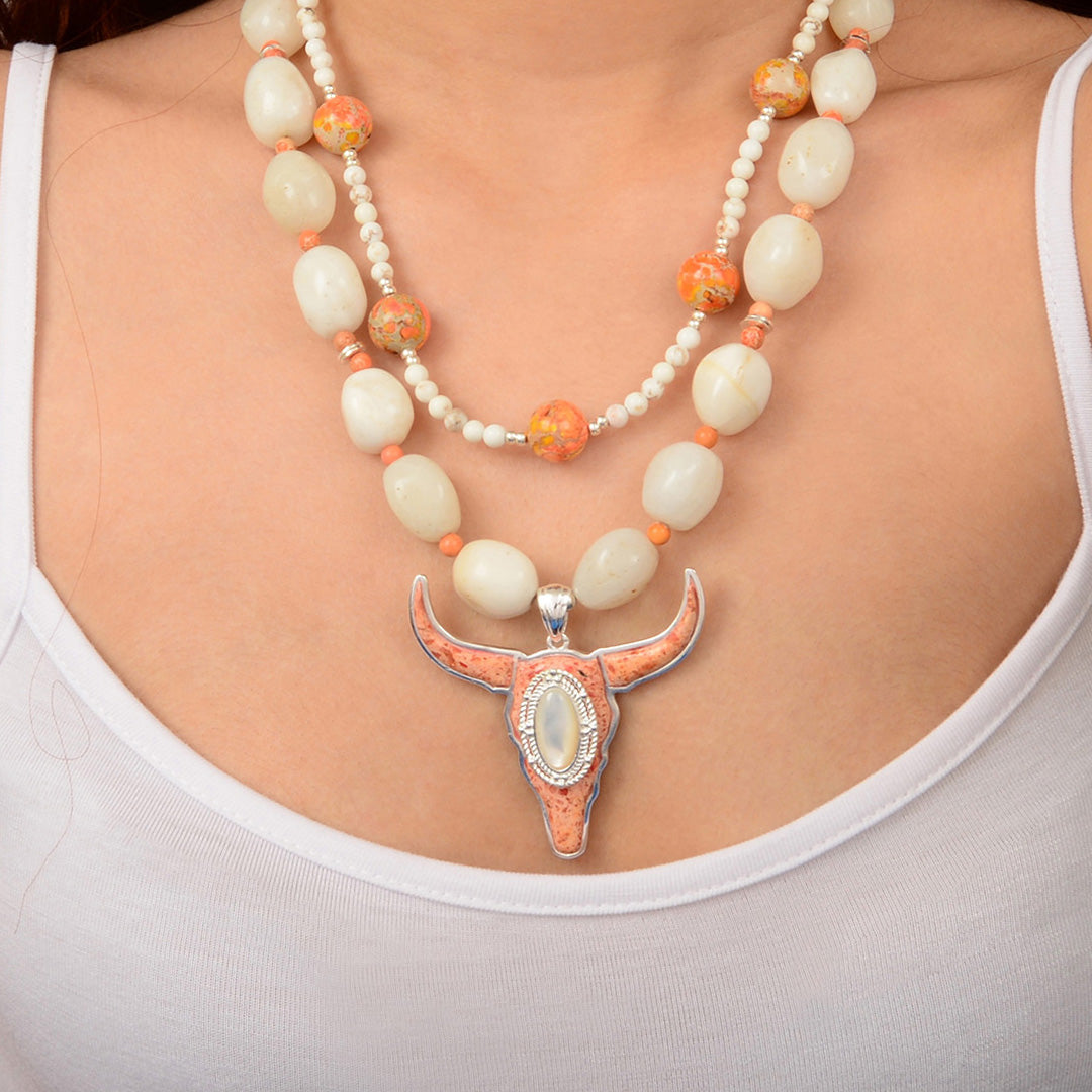 Necklace with a large pendant worn by a person on a plain background