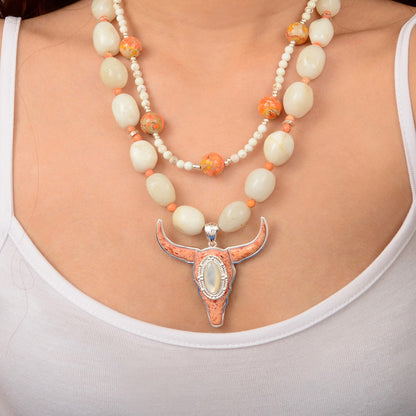 Necklace with a large pendant worn by a person on a plain background