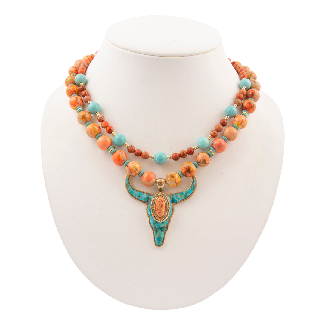 Multistrand beaded necklace with a turquoise pendant on a white mannequin bust.
