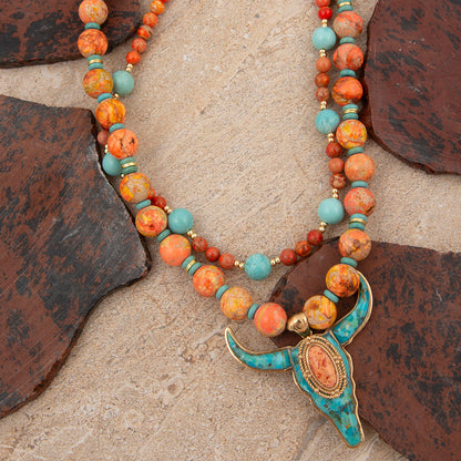 Necklace with colorful beads and a decorative clasp on a stone surface