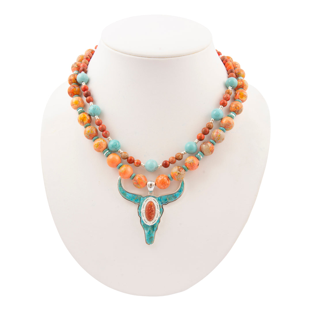 Necklace with multicolored beads and a turquoise pendant on a white mannequin.