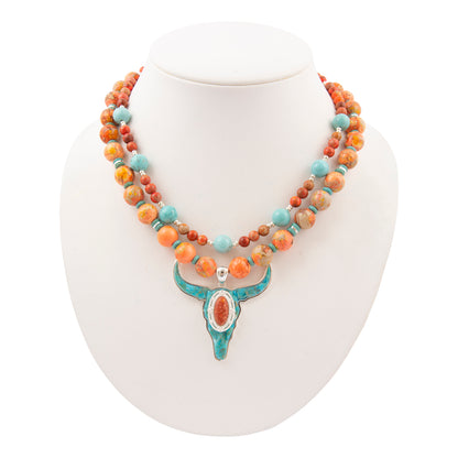 Necklace with multicolored beads and a turquoise pendant on a white mannequin.